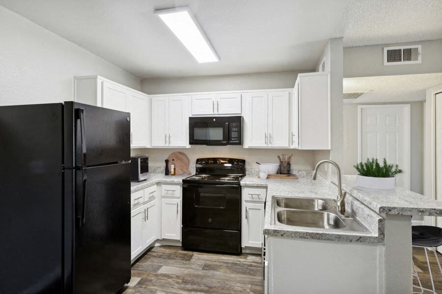 a kitchen with black appliances and white cabinets