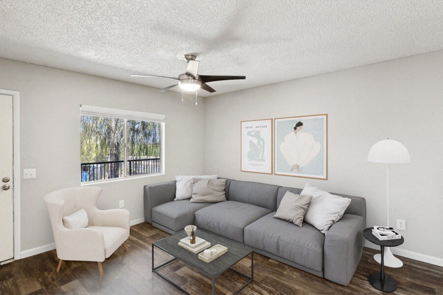 Model apartment living room with a couch and a ceiling fan