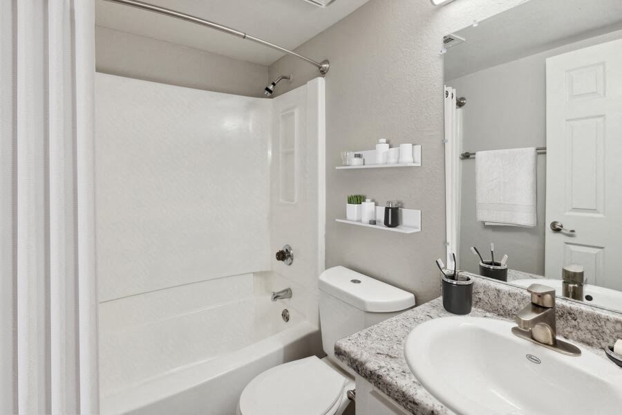 Model apartment bathroom with a sink toilet and a shower
