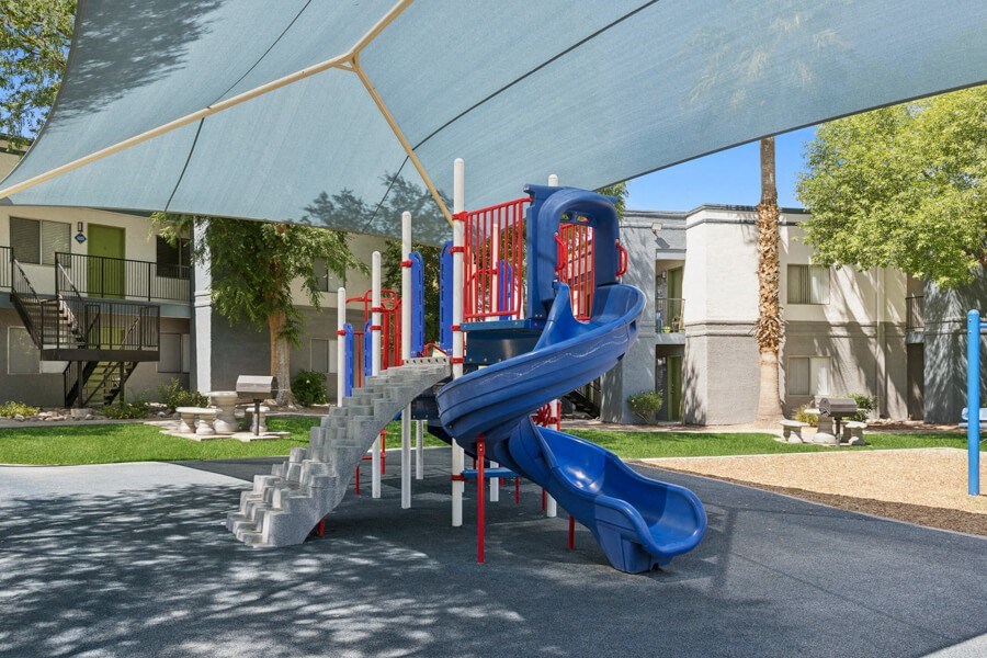 a playground with a blue slide at San Mateo apartments