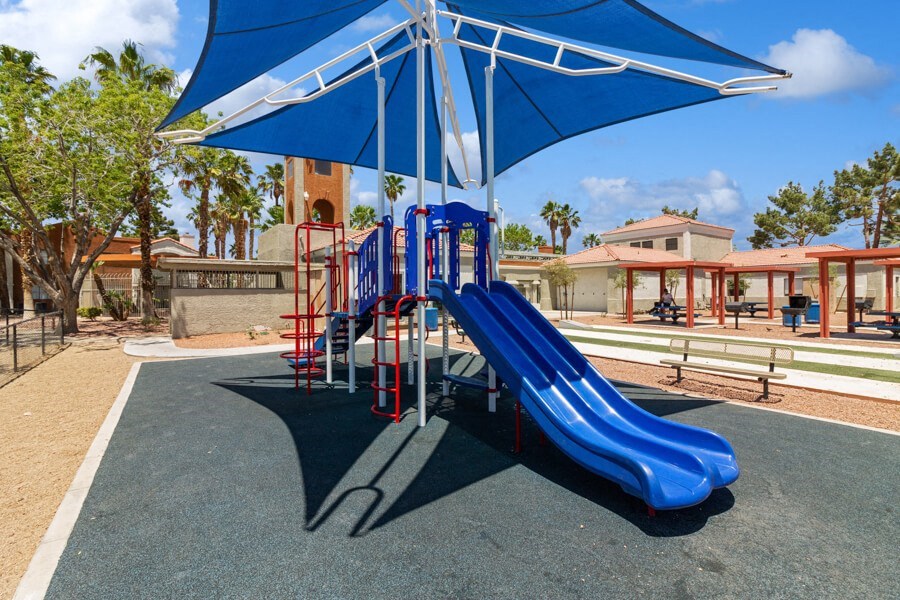 a playground with a blue slide and a red slide