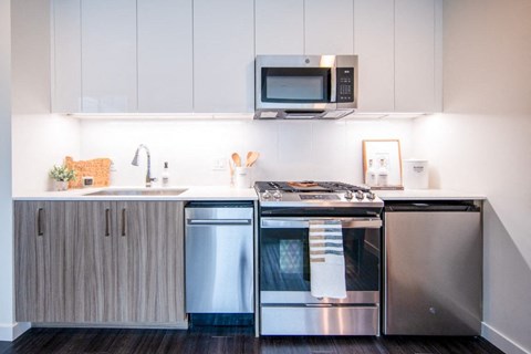 a modern kitchen with stainless steel appliances and white cabinets