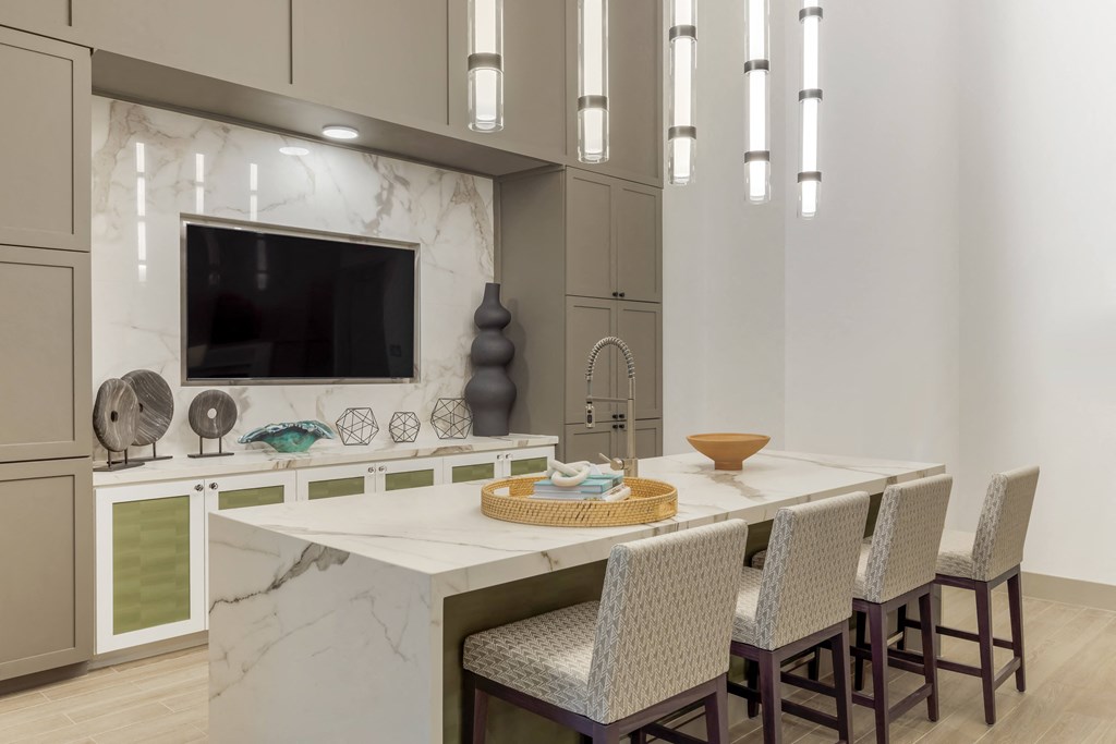 a kitchen with a large center island with a breakfast bar and a flat screen tv