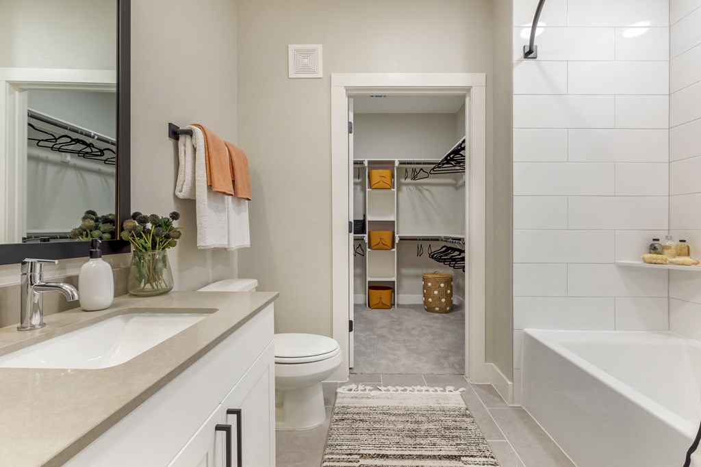 a bathroom with a tub and a toilet next to a sink