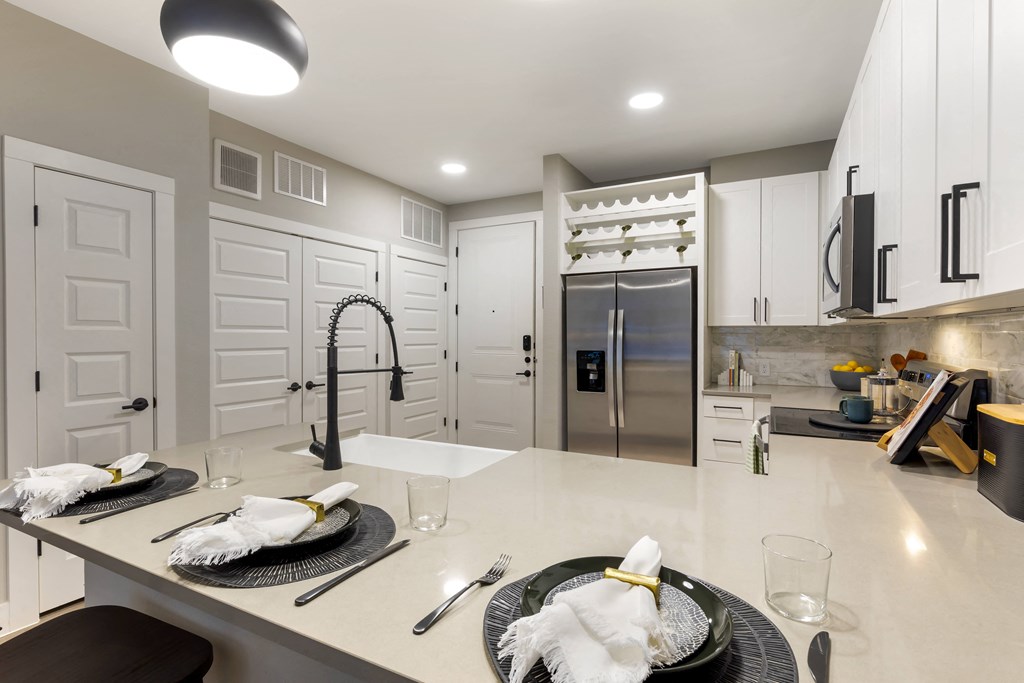 a kitchen with white cabinetry and a large center island with a white countertop