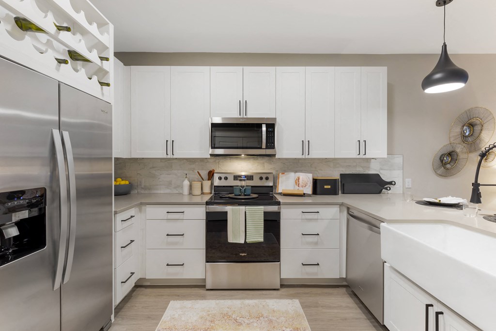 a kitchen with white cabinets and stainless steel appliances