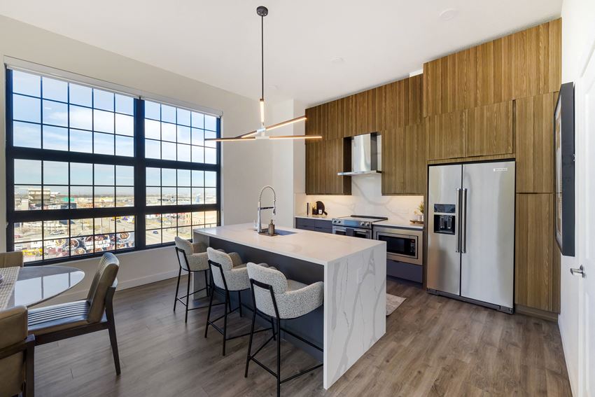 a kitchen with a large center island with a marble countertop