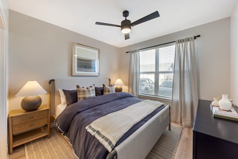 a bedroom with a bed and a ceiling fan