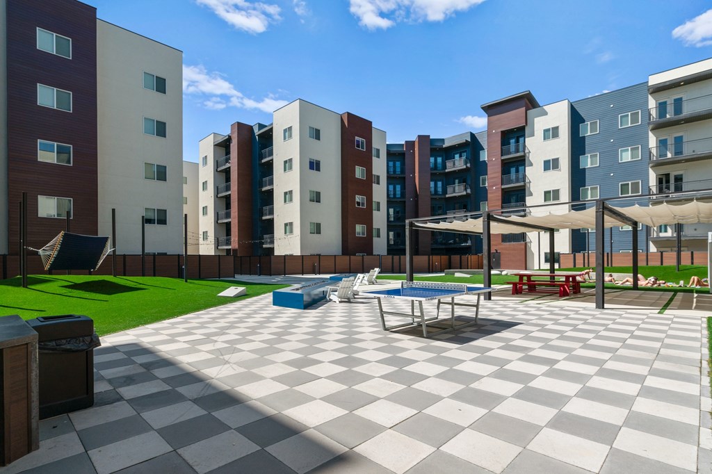 A large checkerboard patterned courtyard in front of apartment buildings.