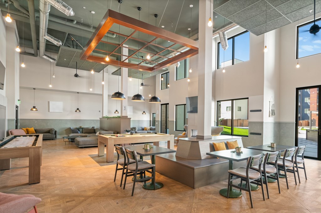 A modern open plan office space with a wooden table and chairs.