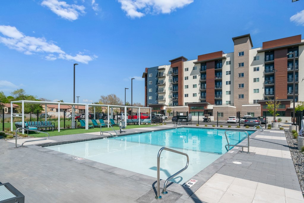 A swimming pool in front of apartment buildings.