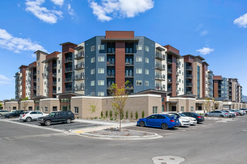 A large apartment complex with a parking lot in front.