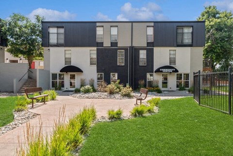 a courtyard with two benches and a bench in front of the apartments