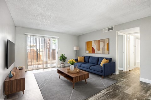 A living room with a blue couch and a wooden coffee table.