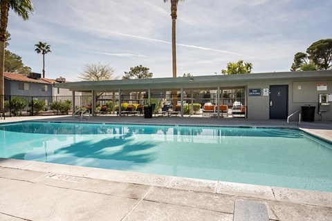 A pool with a building in the background.