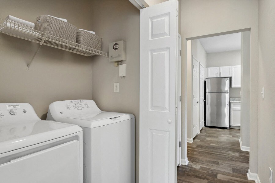 Apartment with a laundry room with a washer and dryer and a kitchen with a refrigerator