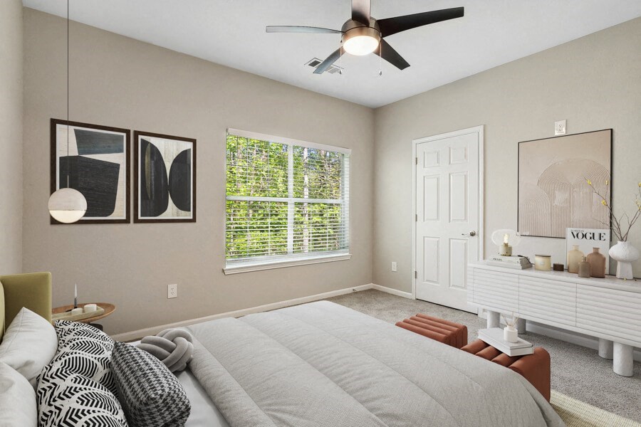 Model apartment bedroom with a large bed and a ceiling fan