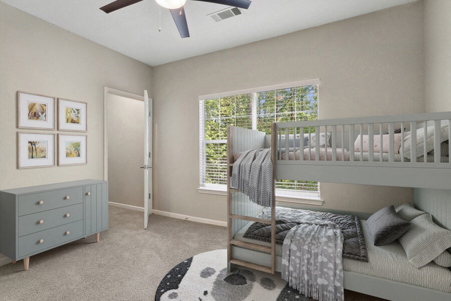 Model apartment bedroom with a bunk bed and a window