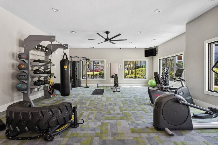 gym with plenty of exercise equipment and windows
