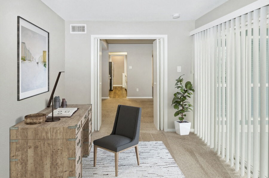 a living room with a desk and a door to a hallway