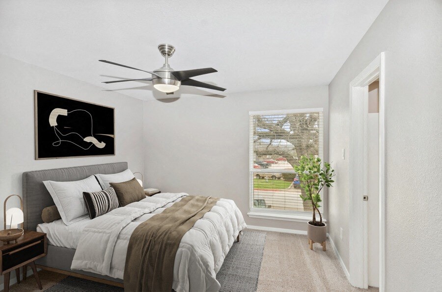 a bedroom with a bed and a ceiling fan