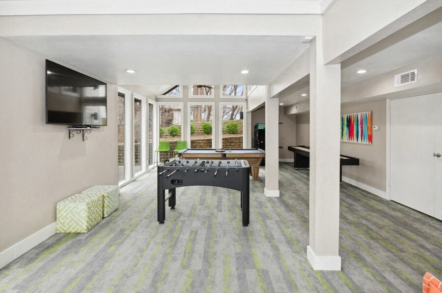 a game room with a pool table and a tv