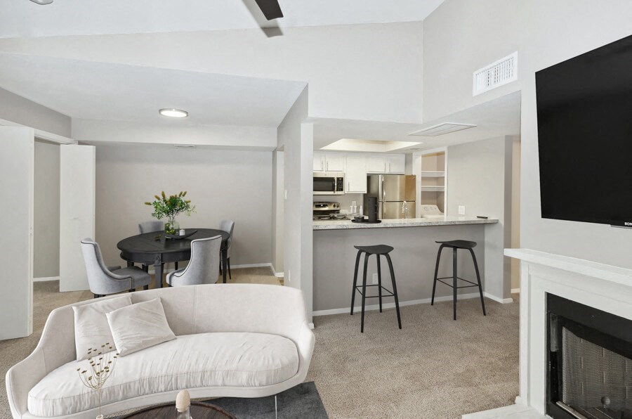a living room with a couch and a kitchen with a bar