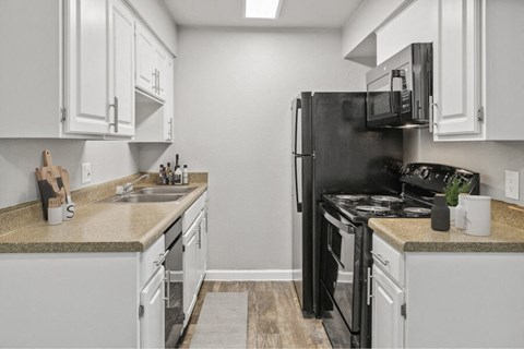 a kitchen with white cabinets and a black refrigerator