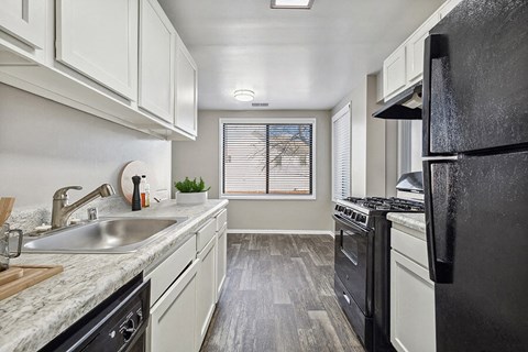 a kitchen with black appliances and white cabinets
