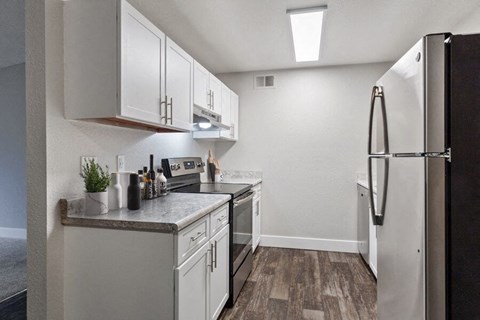 a kitchen with white cabinets and a refrigerator