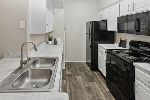 a kitchen with black appliances and white cabinets