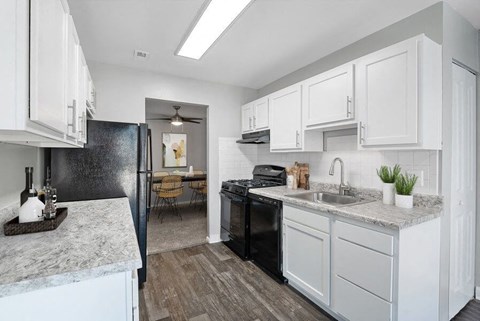 a kitchen with white cabinets and a black refrigerator