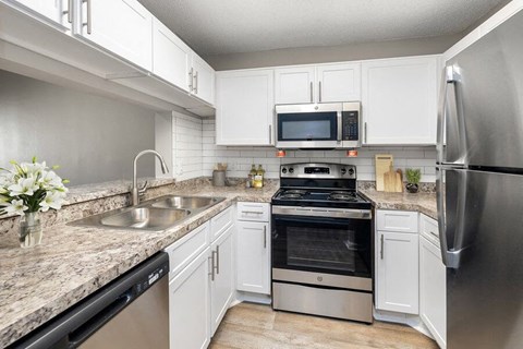 a kitchen with stainless steel appliances and white cabinets