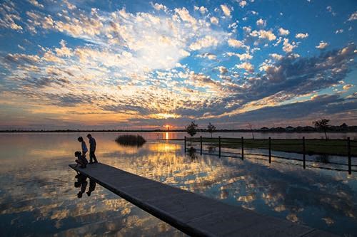 a group of people standing on a dock in the water