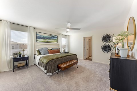 3 Bedroom Single Family Homes for Rent in Pflugerville, TX - Banyan Everton - Bedroom With Plush Carpet, Large Windows, Ceiling Fan, And Upholstered Bed
