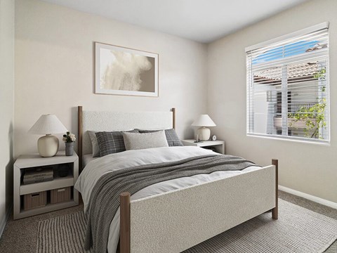 A bedroom with a large bed and two lamps.