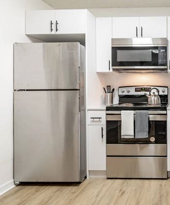 A modern kitchen with a stainless steel refrigerator and oven.