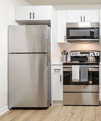 A modern kitchen with a stainless steel refrigerator and oven.
