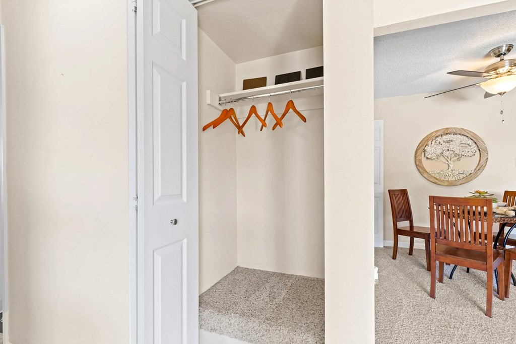 A white door is open to a room with a wooden chair and table.