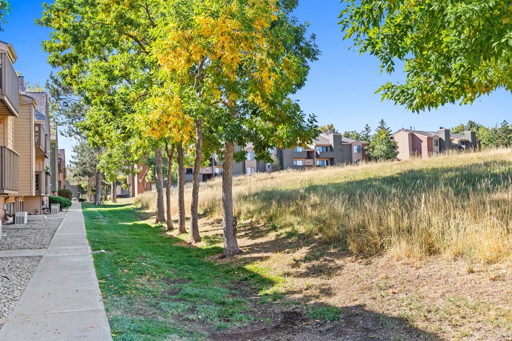 A row of houses with trees in front of them.