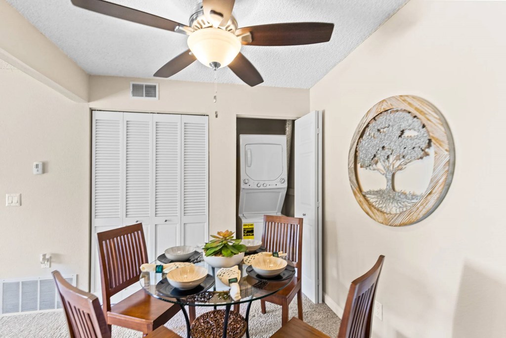 A dining room with a table set for four.
