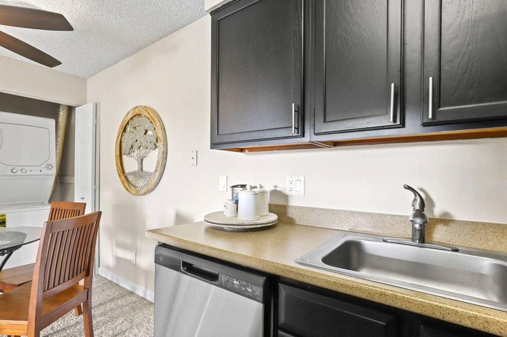 A kitchen with a wooden chair and a clock on the wall.