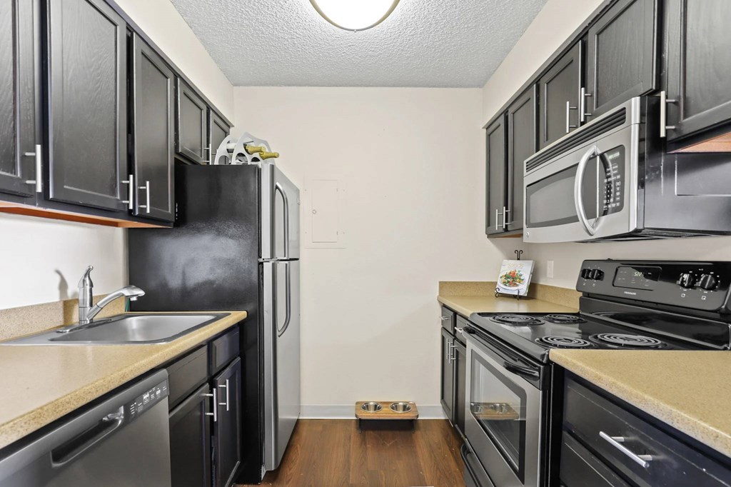A kitchen with black cabinets and stainless steel appliances.