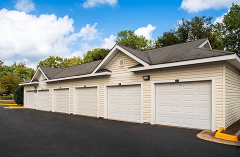 A row of white garage doors in front of a building.