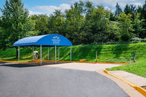 A blue canopy with a white sign that says "Masons Keefe" is in front of a grassy area.
