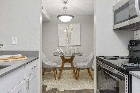 a kitchen with a table and a stove and a microwave
