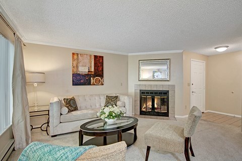 A living room with a fireplace and a painting on the wall.
