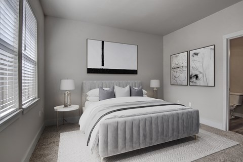A bedroom with a large bed and two lamps.