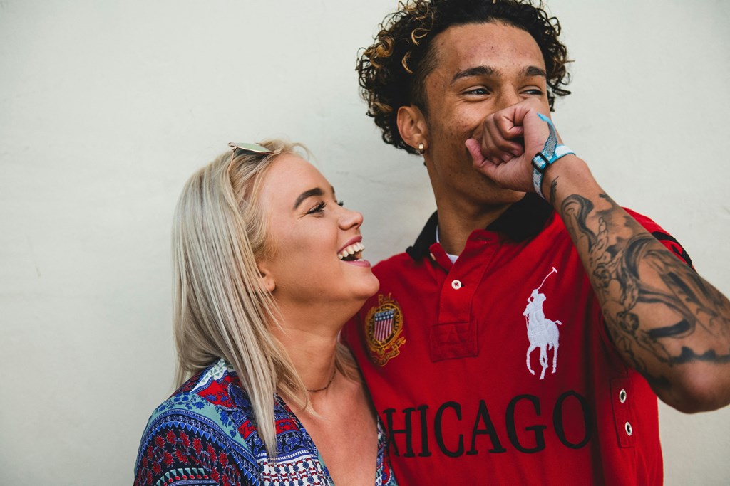 a man and a woman laughing while talking on a cell phone