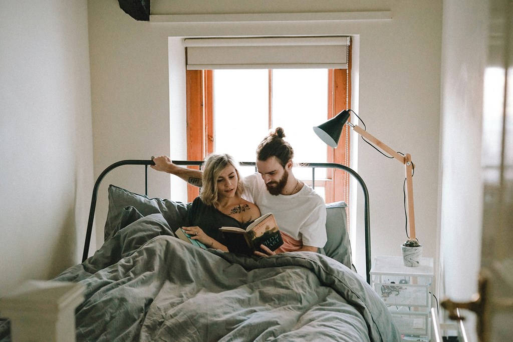 a couple in bed reading a book together